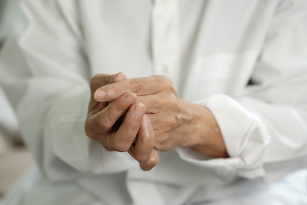 Woman with Rheumatoid Arthritis Clenches Hands