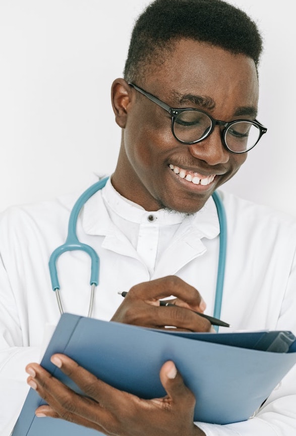 Medical assistant writing patient details on paper